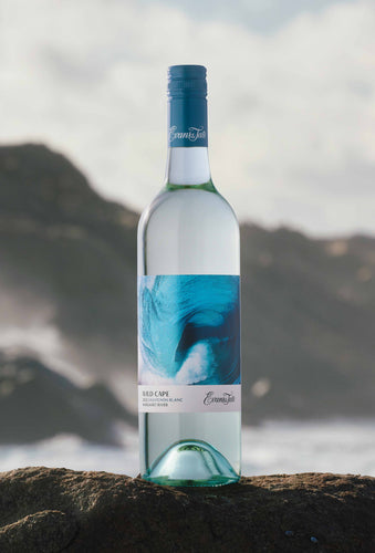Bottle of Wild Cape Sauvignon Blanc wine on a rock at the ocean